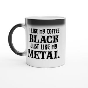 May include: White ceramic coffee mug with a black handle and rim. The mug features the text "I LIKE MY COFFEE BLACK JUST LIKE MY METAL" in a gothic font. The mug is designed for hot beverages.