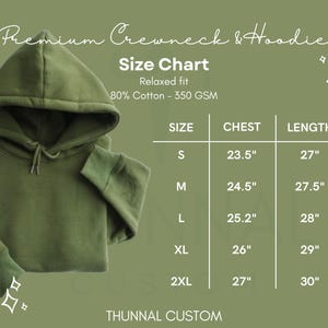 Puede incluir: Una sudadera con capucha verde oliva con cord&oacute;n y una tabla de tallas. La tabla enumera las medidas de pecho y largo en cm para las tallas S a 2XL. El texto dice "Premium Crewneck & Hoodie".