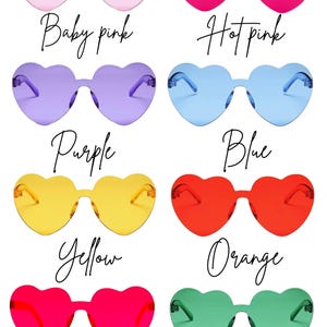 May include: A collection of heart-shaped sunglasses in various colors, including baby pink, hot pink, purple, blue, yellow, orange, red, and green. Each pair has a matching frame and lenses, with the color names written in cursive below.