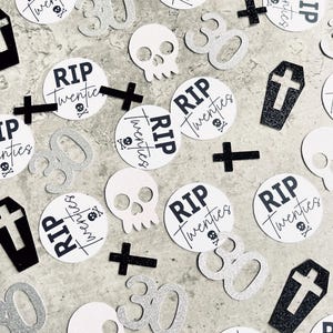 May include: Black and white confetti with the text "RIP Twenties" on several round pieces of confetti. There are also silver glitter numbers "30", white skull and crossbones, and black crosses.