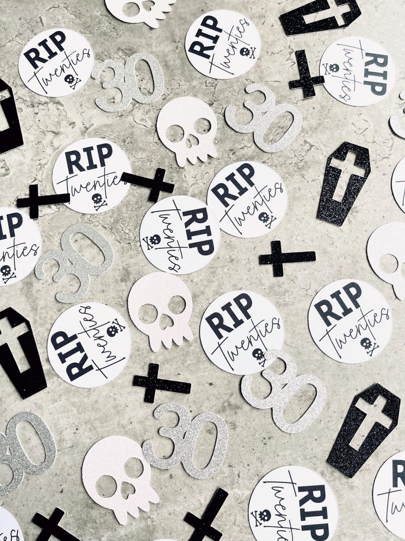 May include: Black and white confetti with the text "RIP Twenties" on several round pieces of confetti. There are also silver glitter numbers "30", white skull and crossbones, and black crosses.