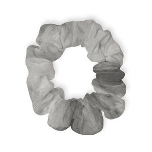 May include: A gray scrunchie with a marbled pattern. The fabric is gathered and folded, creating a textured appearance. The scrunchie is circular and sits against a white background.