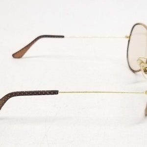 May include: Brown aviator sunglasses with gold metal frames and brown patterned arms.
