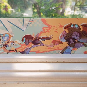 Puede incluir: Una impresión artística rectangular con tres figuras estilizadas en poses de acción. La obra utiliza una paleta de colores naranja, azul y marrón, con líneas dinámicas que sugieren movimiento. El fondo tiene un estilo retro de cómic.