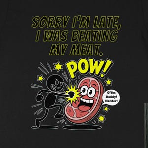 May include: Black t-shirt with a humorous cartoon graphic. The graphic features a stick figure punching a smiling piece of meat, with the text "SORRY I'M LATE, I WAS BEATING MY MEAT. POW!". Additional text includes "O'Yes Daddy! Harder!"