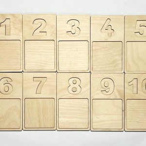 May include: Ten wooden tiles with numbers 1 through 10 printed on them. Each tile has a blank space below the number.