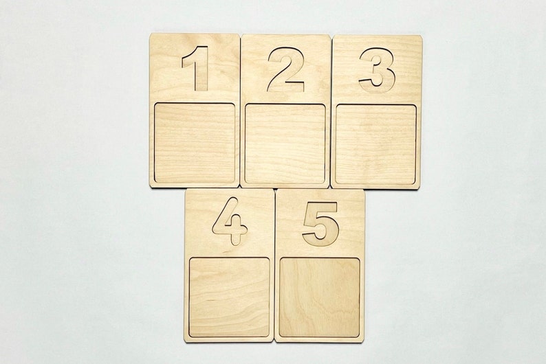 May include: Five wooden squares with numbers 1 to 5 cut out. Each square has a blank space below the number.