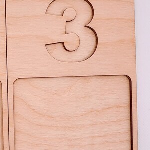 May include: Wooden tray with a cutout of the number 3. The tray has a blank space below the number.