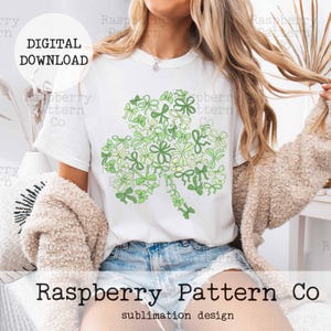Peut inclure: Un t-shirt blanc avec un motif de tr&egrave;fle vert compos&eacute; de n&oelig;uds verts et blancs. Le motif est centr&eacute; sur le t-shirt. Le texte "DIGITAL DOWNLOAD" est dans une bo&icirc;te blanche sur fond noir. Le texte "Raspberry Pattern Co" est sous le t-shirt. Le texte "sublimation design" est sous le nom de l'entreprise.