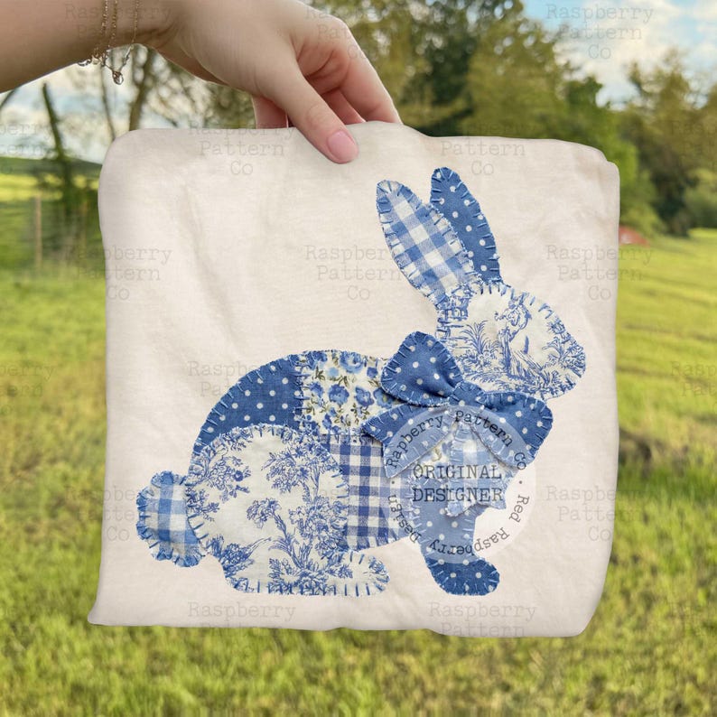May include: A white square fabric with a patchwork bunny design. The bunny is made of blue patterned fabrics, including floral, polka dot, and gingham patterns. A blue bow is at the neck. The text "ORIGINAL DESIGNER" is visible.