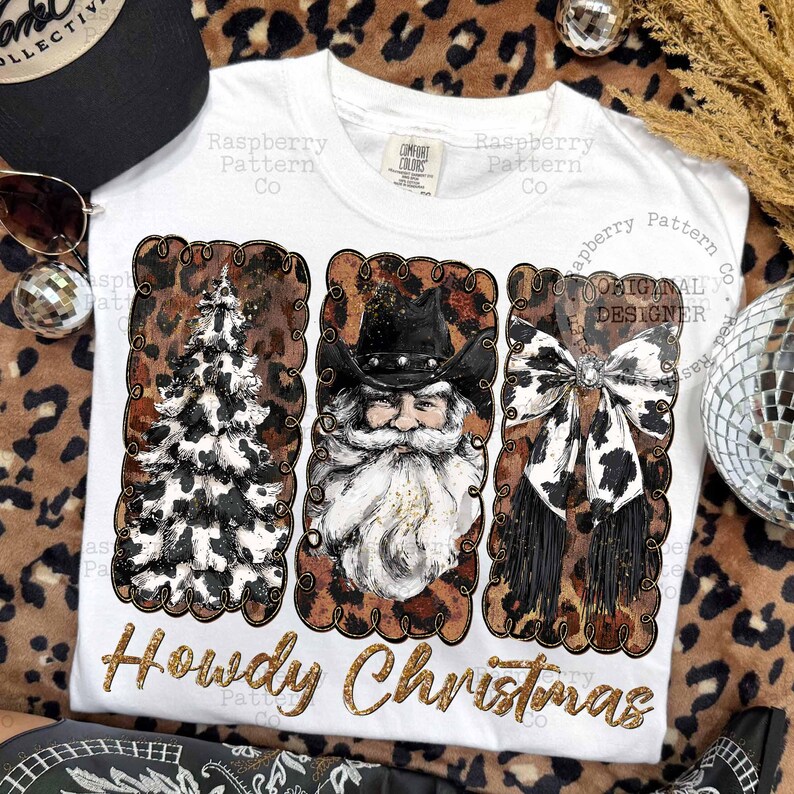 May include: White t-shirt with a festive design featuring a Christmas tree, Santa Claus, and a bow, all with a cowhide pattern. The text "Howdy Christmas" is in gold glitter lettering.