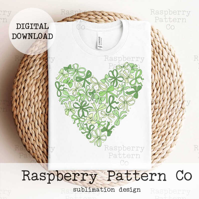 May include: A white t-shirt with a green heart-shaped design made of bows and flowers. The text "Raspberry Pattern Co" is printed below the design. The text "sublimation design" is printed below the company name.