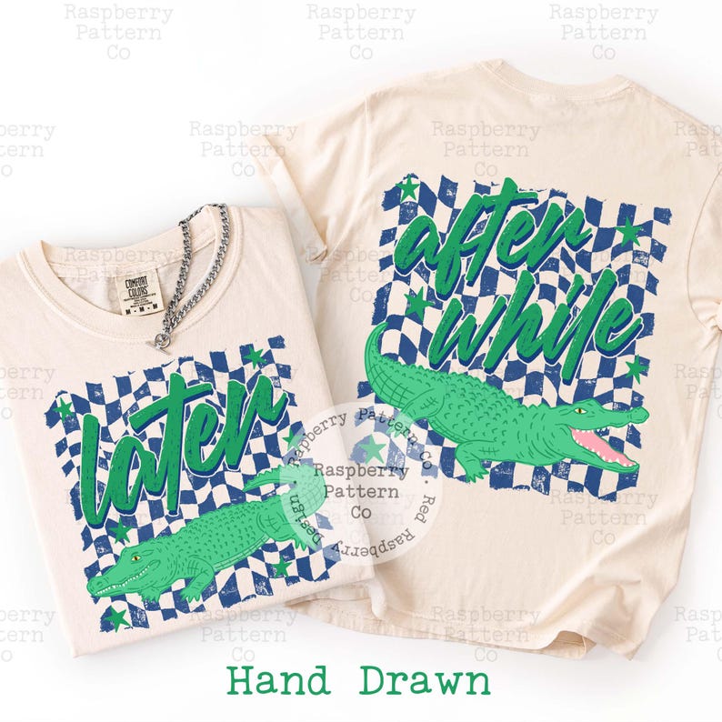 May include: Two cream-coloured t-shirts with green and blue chequered designs. One shirt says "later" with a green alligator graphic, and the other says "after while" with a similar alligator. The words "Hand Drawn" are at the bottom.