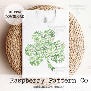 Peut inclure: Un t-shirt blanc avec un motif de tr&egrave;fle vert compos&eacute; de n&oelig;uds verts et jaunes. Le motif est centr&eacute; sur le t-shirt. Le t-shirt est sur une surface tiss&eacute;e. Le texte "Raspberry Pattern Co" est en bas de l'image.