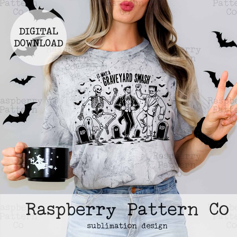 Puede incluir: Un dise&ntilde;o de sublimaci&oacute;n con un esqueleto, un vampiro y un monstruo de Frankenstein bailando con el texto "It was a Graveyard Smash!" impreso en una camiseta gris.