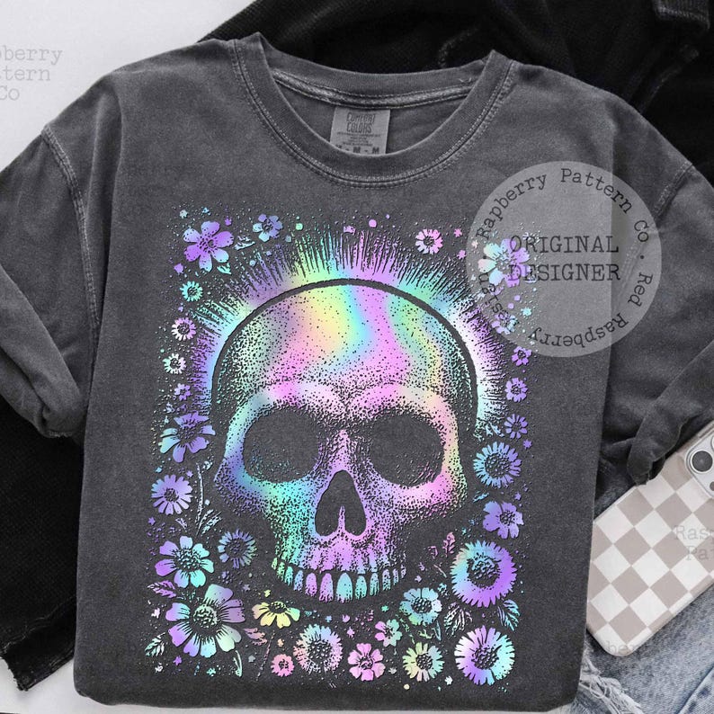 Pu&ograve; includere: Felpa grigio scuro con un design a teschio con un alone arcobaleno e dettagli floreali. Il teschio e i fiori hanno un effetto olografico. Il testo "Original Designer" &egrave; stampato sulla felpa.