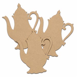 May include: Three flat, light brown, teapot-shaped cutouts made of a smooth, matte material. Each cutout features a curved handle, a long spout, a decorative lid finial, and a wide base, arranged in a cluster against a plain white background.