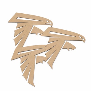 May include: A pair of light brown, flat, laser-cut wooden eagle silhouettes. Each eagle shape features sharp, geometric lines and angular wings, with the two figures overlapping slightly to create a cohesive, stylized avian design.
