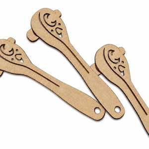 May include: Three light brown, flat, wooden-like cutouts shaped like stylized spoons or ladles. Each piece features a decorative, intricate cutout pattern on the rounded head and a small circular hole at the end of the straight handle.