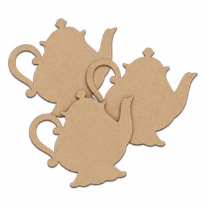 May include: Three flat, light brown, teapot-shaped cutouts made of a smooth, matte material. Each cutout features a curved handle, a spout, a lid with a small knob on top, and a wide base. The three shapes are arranged in an overlapping cluster.