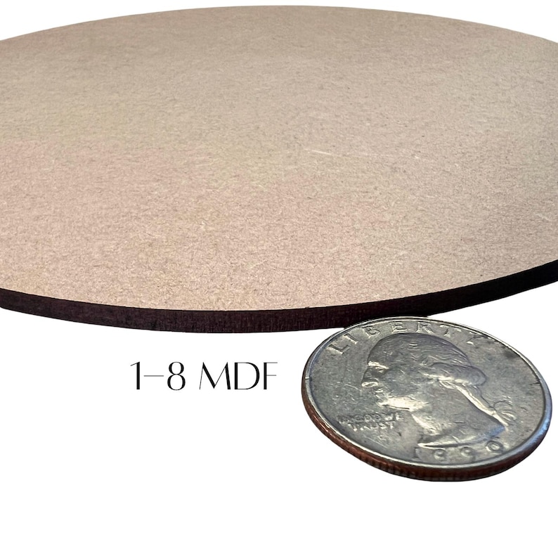 May include: A round, unfinished MDF wood piece with a dark brown edge. The text "1-8 MDF" is printed on the surface. A U.S. quarter coin is placed next to the wood piece for size comparison.