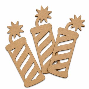 May include: Three wooden firecracker cutouts. Each firecracker is tan with diagonal stripes cut out of the body. A starburst shape tops each firecracker. The cutouts are arranged on a white background.