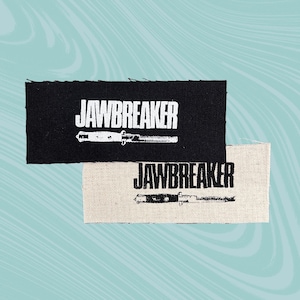 May include: Two black and white fabric patches with the text "JA WBREAKER" and a stylised image of a switchblade knife.