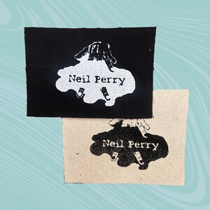 May include: Two fabric patches with the text "Neil Perry" printed in white on a black patch and black on a white patch. The design features a hand reaching into a puddle.