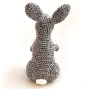 May include: A gray crocheted bunny rabbit with a white crocheted tail.