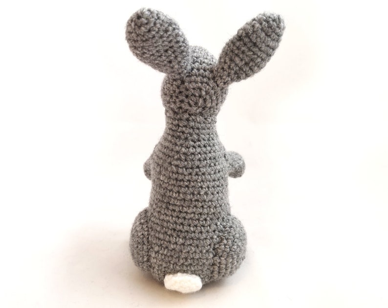 May include: A gray crocheted bunny rabbit with a white crocheted tail.