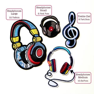 May include: Four embroidered iron-on patches featuring headphones in different sizes, a treble clef, and the text "Headphones Large 12.7x8cm", "Headphones Small 5.7x4.7cm", "Treble Clef 9.7x4.5cm", and "Headphones Medium 10.5x7cm".