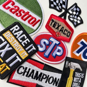 Può includere: Una collezione di toppe ricamate con temi automobilistici e di corse. I disegni includono il logo Castrol, bandiere a scacchi, Texaco, STP e il numero 76. Altre toppe presentano le scritte "RACE IT DESTROY IT", "CHAMPION" e "THIS IS NOT A DRILL".