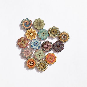 May include: Assortment of 15 colourful wooden buttons with intricate floral patterns. The buttons are round and have two holes each. They are perfect for adding a touch of whimsy to any craft project.
