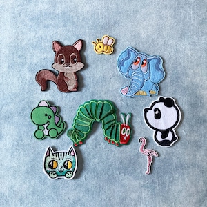 Könnte beinhalten: Ein Set mit zehn Bügelbildern mit verschiedenen Comic-Tieren, darunter eine Raupe, ein Eichhörnchen, ein Panda, eine Katze, ein Flamingo und ein Elefant. Die Patches sind bunt und fantasievoll und eignen sich perfekt, um Kleidung, Taschen oder anderen Accessoires eine persönliche Note zu verleihen.