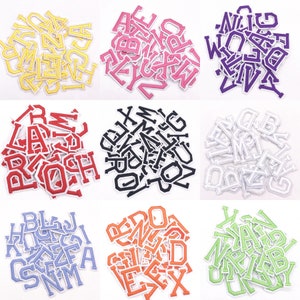 May include: Assortment of iron-on alphabet letters in various colors, including yellow, pink, red, black, white, blue, orange, and green. Each letter is individually cut out and ready to be ironed onto fabric.
