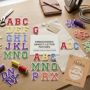 Può includere: Una collezione di toppe ricamate con lettere in stile varsity in vari colori tra cui rosso, giallo, blu, verde, viola e arancione. Il set include una carta bianca con il testo EMBROIDERED VARSITY LETTER PATCHES e un'etichetta Patches & Pins.
