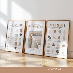 Pode incluir: Três cartazes educativos emoldurados com molduras douradas. Os cartazes exibem texto francês e ilustrações de números, formas, tabelas de multiplicação e sólidos geométricos em tons neutros. A palavra "CALYPSO" está no canto inferior direito.