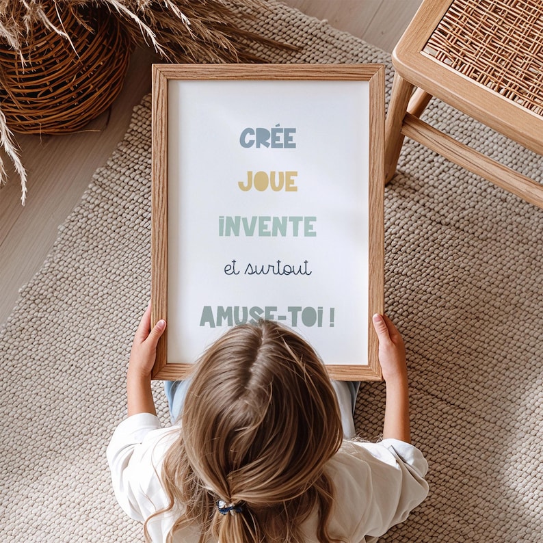 Poster citation ludique pour chambre enfant, lettres colorées en bleu vert et jaune sur fond blanc, affiche motivante et joyeuse encadrée bois clair