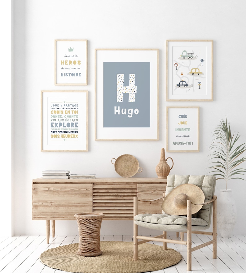 Quatre impressions encadrées avec du texte inspirant et un fond bleu. Les impressions présentent les mots "Héros", "Hugo", "Explorer" et "Créer, jouer, inventer et s'amuser".