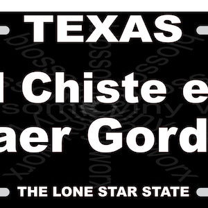 May include: Black and white Texas licence plate with the text "El Chiste es Caer Gordo" and the words "THE LONE STAR STATE" at the bottom.