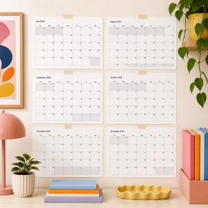 Può includere: Sei fogli di calendario da parete bianchi da luglio a dicembre 2026, ciascuno caratterizzato da un layout a griglia con testo nero per mesi e giorni. I fogli sono fissati con nastro adesivo color sabbia. Il calendario mostra una struttura mensile standard con caselle ombreggiate in grigio.