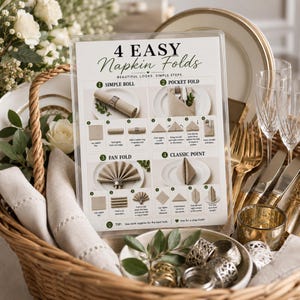May include: A clear acrylic sign titled 4 EASY Napkin Folds with instructional diagrams for a simple roll, pocket fold, fan fold, and classic point. The sign is displayed in a wicker basket with linen napkins, gold cutlery, and metal napkin rings.