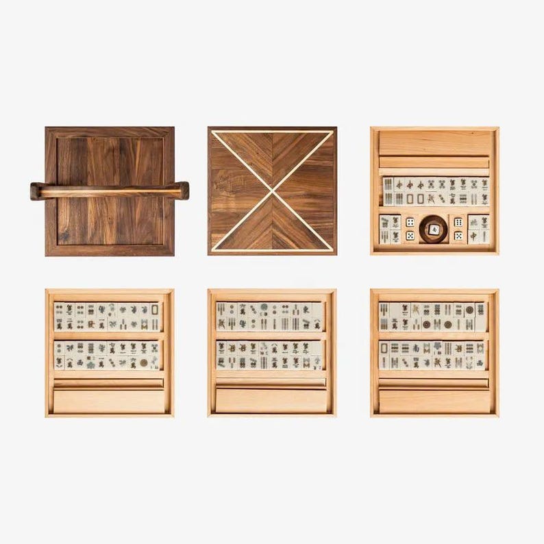 May include: A set of wooden mahjong tiles in a wooden box with a wooden tray. The tiles are arranged in a grid pattern and feature black and white characters. The box has a hinged lid and a handle. The tray is rectangular and has a raised edge.