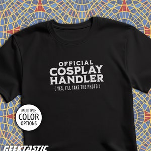 May include: Black t-shirt with white text that reads "OFFICIAL COSPLAY HANDLER (YES, I'LL TAKE THE PHOTO)".