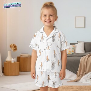 Puede incluir: Conjunto de pijama blanco para ni&ntilde;os con un patr&oacute;n caprichoso de personajes de dibujos animados y plantas. La parte superior de manga corta y los pantalones cortos tienen ribetes blancos. El pijama est&aacute; hecho de un material suave y c&oacute;modo.