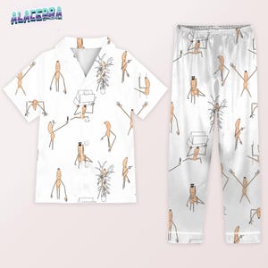 Puede incluir: Conjunto de pijama blanco con un dise&ntilde;o de personaje de dibujos animados repetido. La parte superior de manga corta tiene cuello y cierre de botones. Los pantalones de pijama tienen cintura el&aacute;stica. Los personajes de dibujos animados est&aacute;n en varias poses.