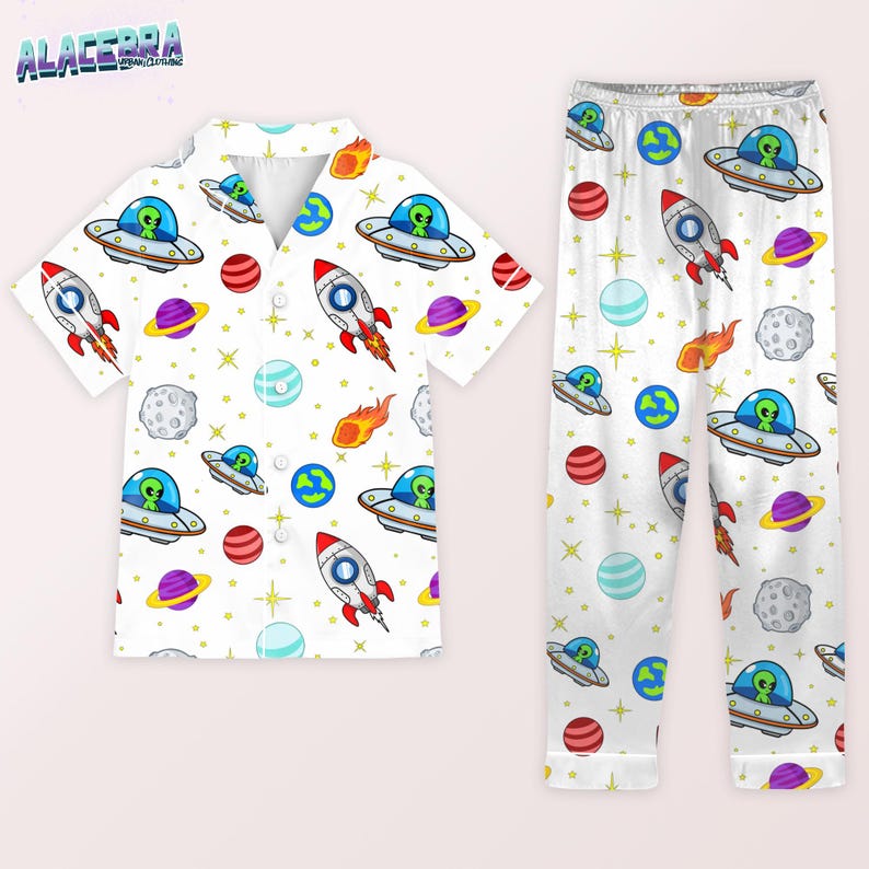 Puede incluir: Conjunto de pijama blanco con un estampado repetido de extraterrestres de dibujos animados en ovnis, cohetes, planetas y estrellas. La parte superior de manga corta tiene una botonadura. El pantal&oacute;n de pijama tiene cintura el&aacute;stica.