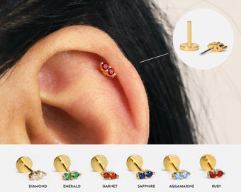 May include: Gold ear cartilage piercing with a choice of gemstone: diamond, emerald, garnet, sapphire, aquamarine, or ruby.