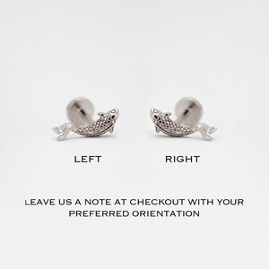 May include: Two silver fish earrings, one facing left and one facing right. The earrings are shown against a white background. Leave a note at checkout with your preferred orientation.