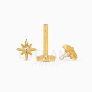 Pode incluir: Pe&ccedil;as de joalharia douradas, incluindo um brinco em forma de estrela, um poste de costas planas e um brinco de rosca com um design de estrela. As pe&ccedil;as s&atilde;o exibidas sobre um fundo branco, mostrando os detalhes intrincados da joalharia.